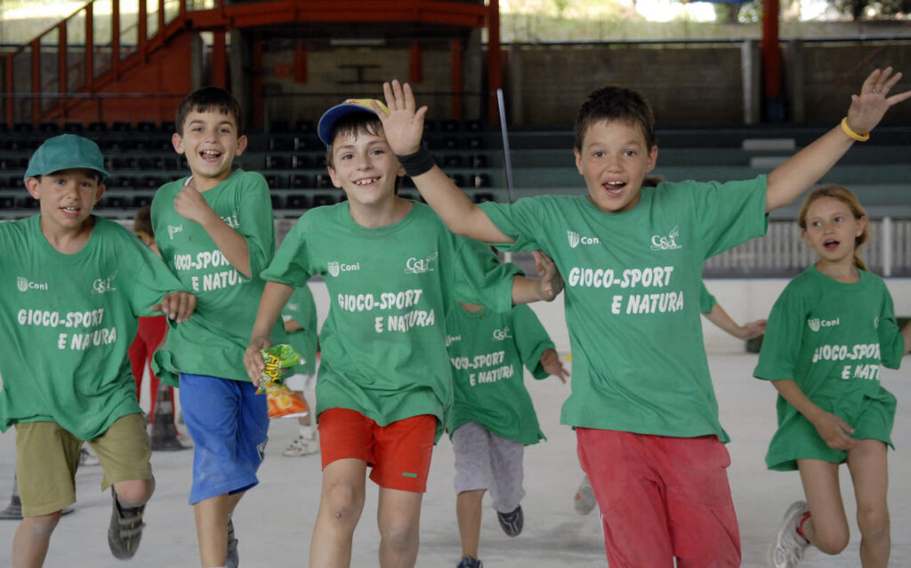 Gruppo di bambini che corrono felici facendo sport al campionato di raccolta fondi Dai Como